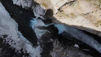 Winter drone view of Karakaya-Su waterfall. A powerful stream bursts out of the rocks. Icicles around the waterfall video