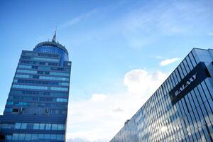 Glass building with transparent facade of the building and blue sky. Structural glass wall reflecting blue sky. Abstract modern architecture fragment. Contemporary architectural background. photo