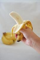 Banana on a wooden plate in the hands of a girl. Selective focus. photo