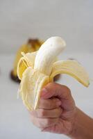 Banana on a wooden plate in the hands of a girl. Selective focus. photo