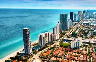 Aerial View of Miami City and Ocean, Captivating Urban Landscape Meeting Vast Waters. An awe-inspiring aerial perspective showcasing the dynamic blend of Miami cityscape and the tranquil ocean. photo