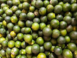 Top view of fresh green lemons as a background. photo