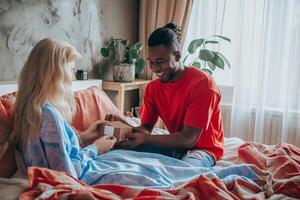 AI generated A young brunette man gives a gift for International Women's Day to his girlfriend in the morning who is dressed in pajamas photo