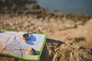 Finding your way with compass and map on the top of the rock overlooking the Atlantic ocean. photo