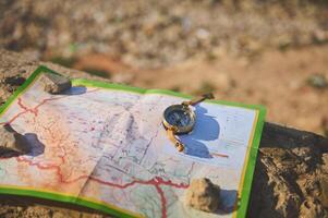 de cerca de un antiguo Brújula y geográfico mapa en un roca. viaje. turismo foto