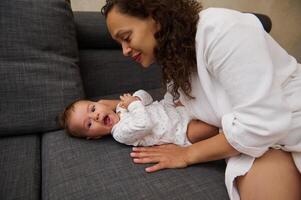 Smiling woman enjoying nice moments with her baby boy indoor. Childcare. Childbirth. Maternity leave and infancy concept photo