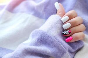 Beautiful female hands with manicure on a purple background. Tinted nail design. Summer pink manicure. Copy space. photo