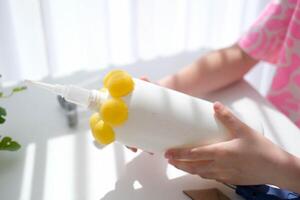 paso a paso instrucciones para haciendo artesanía desde improvisado materiales hecho a mano a colegio arte cohete para el día de cosas de cosmonautas. el niño es pegar partes a un el plastico botella. paso 11 foto