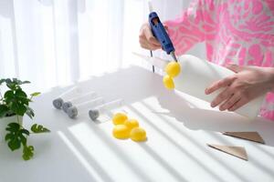 Step-by-step instructions for making crafts from improvised materials. Handmade at school craft rocket for the day of cosmonautics. The child is gluing parts to a plastic bottle.  Step 6 photo