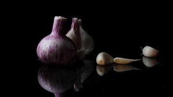 cebollas, ajo y especias aislado en negro antecedentes. marco. composición de cebollas y que cae ajo aislado en blanco antecedentes video