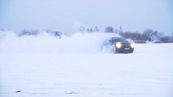 auto maken u-bocht in de sneeuw. sport- auto schijven in de sneeuw. blauw crossover doet trucs in de sneeuw video