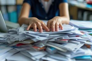 AI generated Hands of a person desperately trying to work on a keyboard buried under a mountain of unorganized paperwork, symbolizing extreme work overload. photo