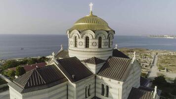 Visão do a grande branco Igreja com dourado cúpulas dentro frente do lindo rio, Primavera Vologda, Rússia. tomada. lindo aéreo a partir de a pássaro olho Visão para a grande Igreja em a rio banco. video