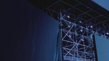 Silhouette von ein Mann reparieren Konzert Ausrüstung. das Bühne Arbeiter setzt oben das Beleuchtung. video