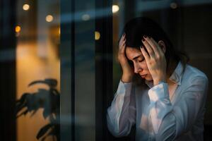 ai generado Deprimido tristemente grave asiático negocio mujer teniendo Estresante depresión triste hora trabajando en ordenador portátil en oficina mesa. depresión mujer triste serie mental salud desde trabajando concepto. foto