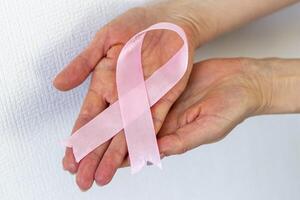 Disparo de un mujer participación rosado cinta, símbolo de un pecho cáncer conciencia. concepto foto