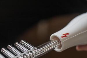 Close up shot of the high frequency comb tool for hair and scalp treatment. Healthcare photo