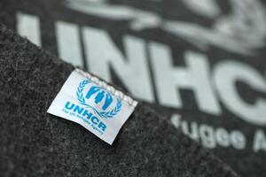 Kyiv, ucrania - 4 de mayo de 2022 acnur el logotipo de la agencia de refugiados de la onu en mantas grises humanitarias foto