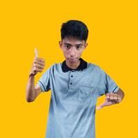 Happy smiling face of young asian man gray t-shirt yellow background photo