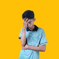 confused asian young man yellow t-shirt, isolated white background photo