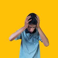 confuso asiático joven hombre gris camiseta, aislado amarillo antecedentes foto