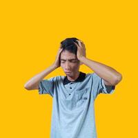 confused asian young man yellow t-shirt, isolated white background photo