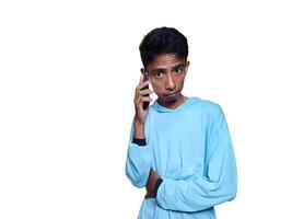 Close-up of Asian man talking on cell phone standing facing camera on white background. photo