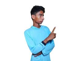 excited asian man wearing blue t-shirt pointing to the copy space on the side, isolated white background. photo