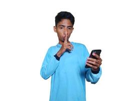 Young Asian man making a secret sign gesture calm sound white background. photo