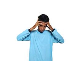 Dizzy face holding head of young Asian man in yellow shirt isolated on white background photo