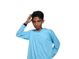 confuso asiático joven hombre azul camiseta, aislado blanco antecedentes foto
