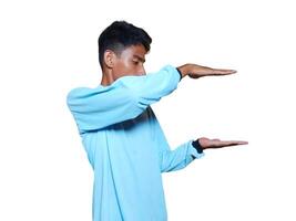 Excited Asian man wearing blue t-shirt pointing at copy space on the side, isolated on white background. photo