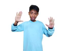 joven asiático hombre vestido en azul camiseta levantamiento brazo diciendo Hola reunirse amigo aislado blanco antecedentes. foto