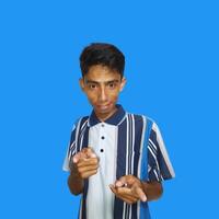 Young Asian man pointing at the camera with index finger, blue background. photo