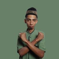 young asian male crossed arms with happy face isolated green background photo