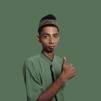 Asian man smiling face with okay gesture, isolated on green background photo