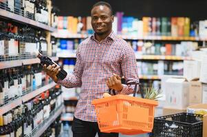 African American Man in a supermarket choosing a wine photo