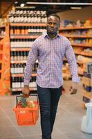 Young african man buying in grocery section at supermarket photo