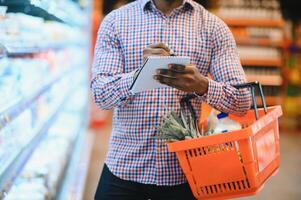 Young african man buying in grocery section at supermarket photo