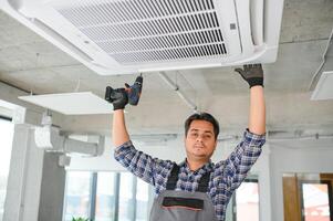 specialist cleans and repairs the wall air conditioner photo