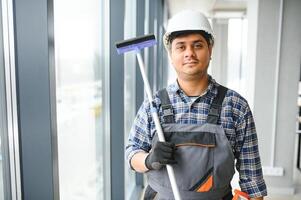 masculino profesional limpieza Servicio trabajador limpia el ventanas y tienda ventanas de un Tienda con especial equipo foto