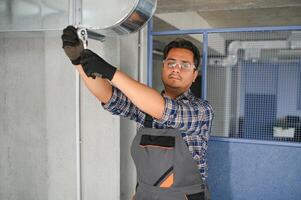 Ventilation cleaning. Specialist at work. Repair ventilation system. Industrial background photo