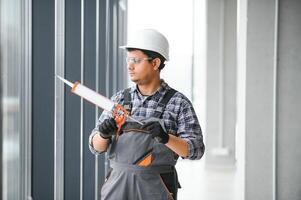 The worker installs a window frame in the room photo