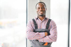 Smiling construction worker with arms crossed at site photo