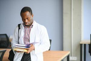 Portrait of medical student. Young African American doctor read book, and documents preparing for exams photo