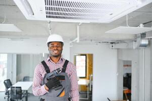 african Male Technician Repairing Air Conditioner. photo