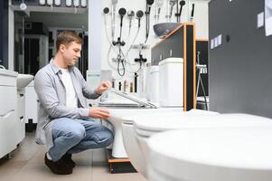 Man choosing home toilet in store photo