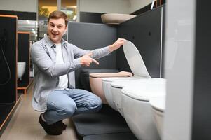 Man choosing home toilet in store photo