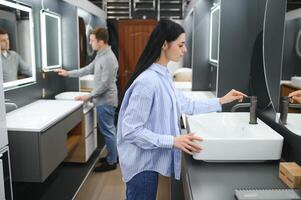 Young family couple choosing bathroom sink in bathroom fixtures store photo