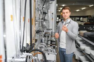 A buyer shopping for bathroom equipment in hardware store. Touching faucet crane or water tap photo